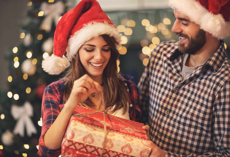Cheerful,Man,And,Woman,Opens,Christmas,Gift