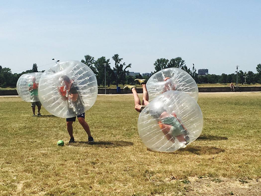 Kolegovia hrajú futbal v priesvitnej nafuknutej plastovej guli. Zorbing futbal. Vhodná aktivita pre teambuilding.